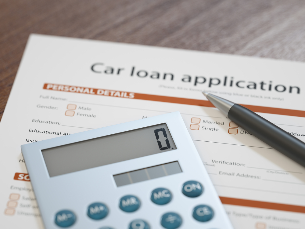 Car loan paperwork and calculator symbolizing financing challenges like negative equity